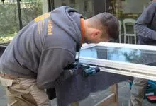 Schreiner bei der Reparatur eines Fensters